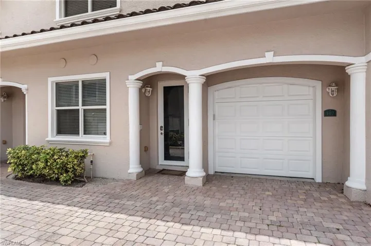 Entrance to property featuring a garage, stucco siding, and decorative driveway