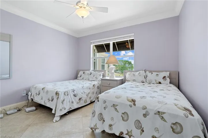 Bedroom featuring crown molding, ceiling fan, and light tile patterned floors