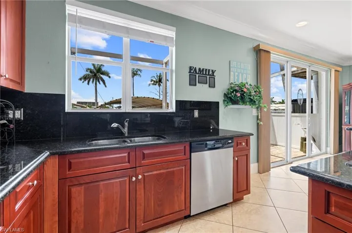 Kitchen with a sink, decorative backsplash, dishwasher, and ornamental molding
