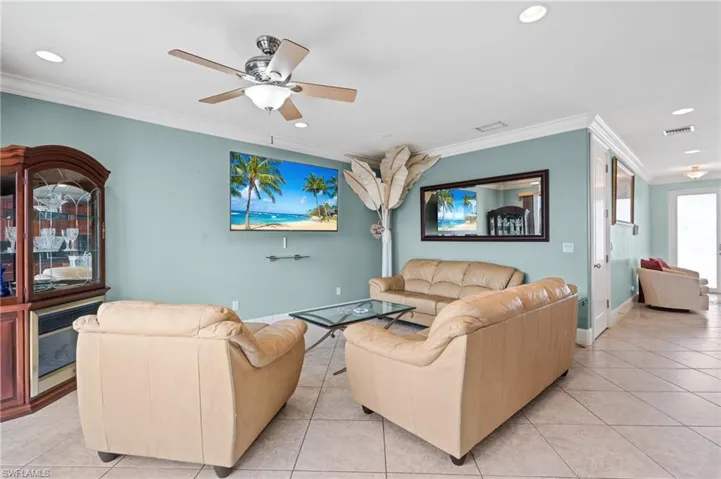 Living area featuring recessed lighting, ornamental molding, and light tile patterned floors
