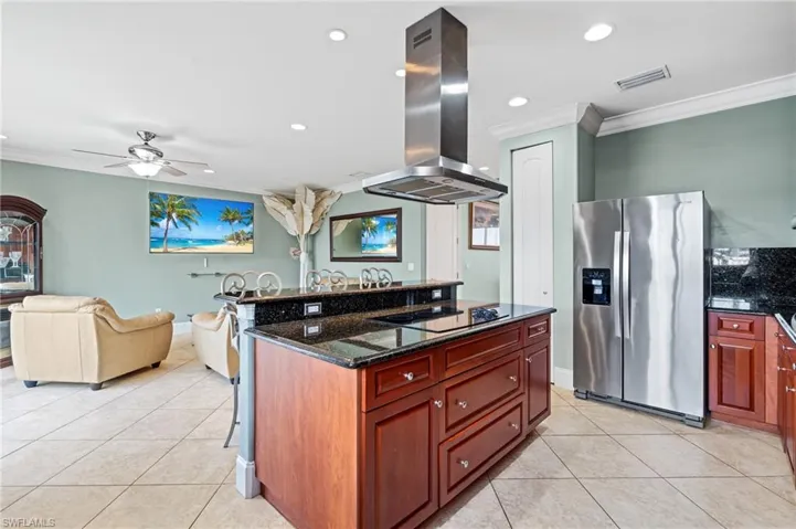 Kitchen featuring stainless steel fridge, crown molding, black electric stovetop, and island exhaust hood