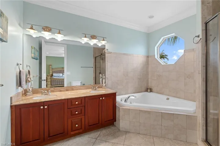 Bathroom featuring a double sinks, jetted tub tile patterned floors