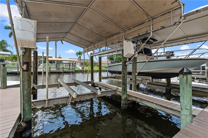 Dock area featuring boat lift and a water view