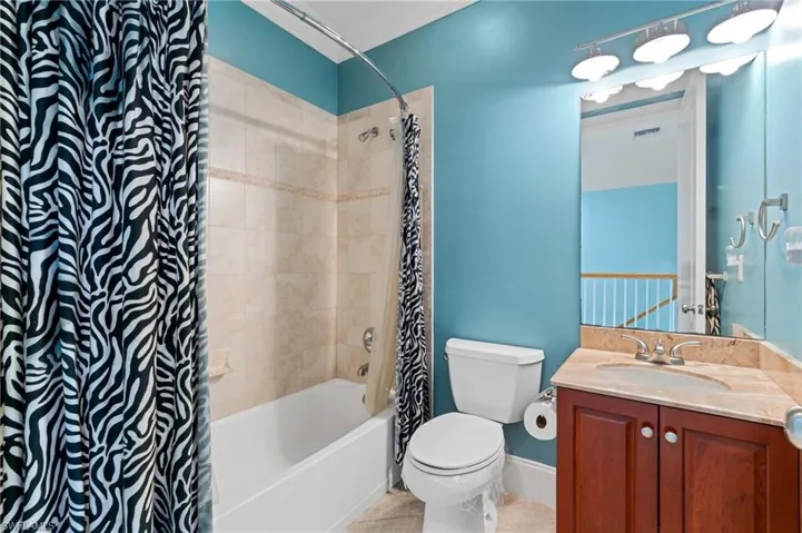 Bathroom with vanity, tile patterned floors, and shower / bath combo