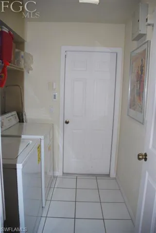Walk in utility room with washer dryer, shelving, entry to garage from home