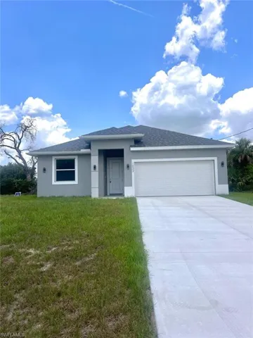 View of front of property featuring a front yard and a garage