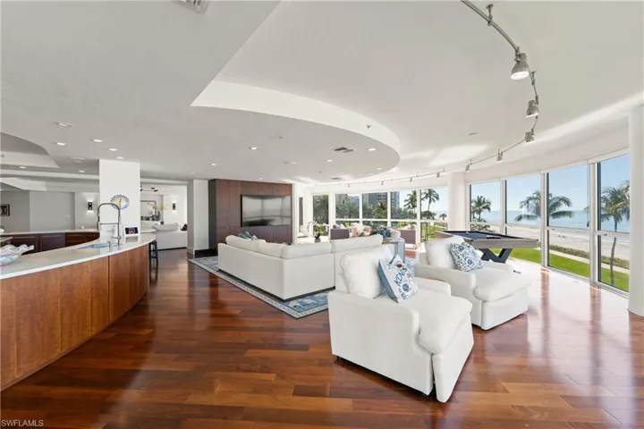 Living room featuring a wall of windows, dark wood finished floors, track lighting, and billiards