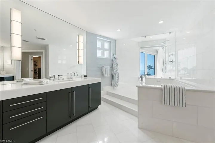 Bathroom featuring vanity, a walk in shower, and recessed lighting