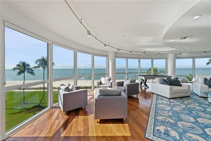 Sunroom / solarium featuring a water view and track lighting