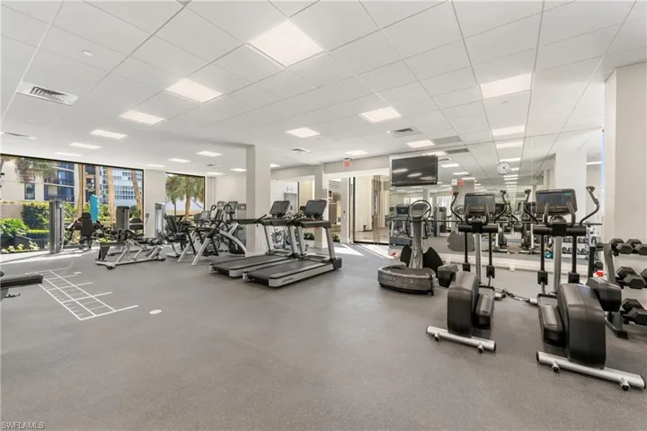 Exercise room featuring a paneled ceiling and floor to ceiling windows