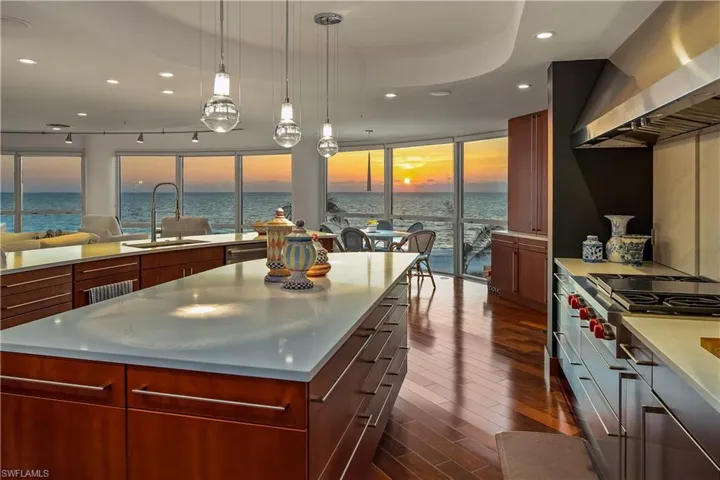 Kitchen featuring wall chimney range hood, sink, and a water view