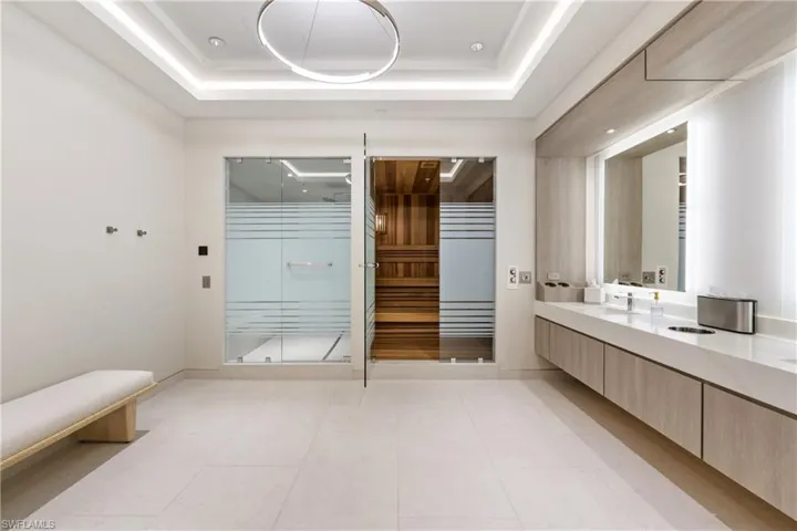 Bathroom featuring double vanity, a stall shower, and a sauna / steam room