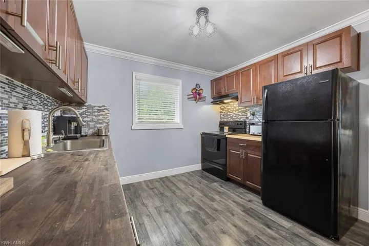 kitchen featuring backsplash and wood countertops