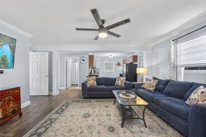 Living room featuring crown molding, vinyl floors, and a healthy amount of natural light