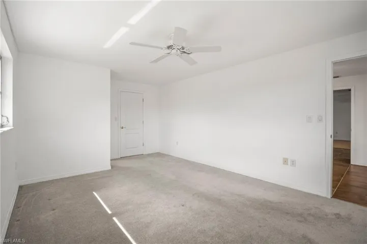 Empty room featuring baseboards, ceiling fan, and carpet flooring