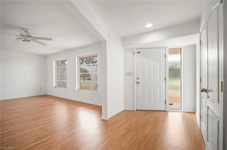 Entryway with light wood finished floors, ceiling fan, baseboards, and plenty of natural light