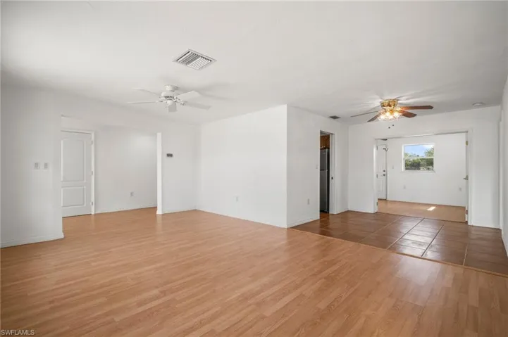 Unfurnished living room featuring a ceiling fan, visible vents, baseboards, and light wood-type flooring