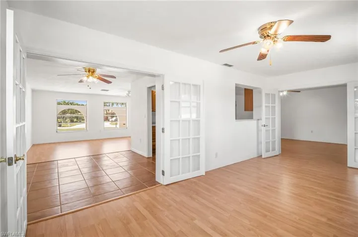 Spare room with visible vents, wood finished floors, ceiling fan, and french doors