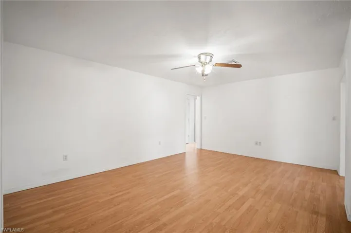 Unfurnished room with baseboards, ceiling fan, and light wood-style flooring