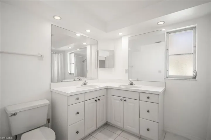 Bathroom featuring toilet, recessed lighting, curtained shower, and vanity