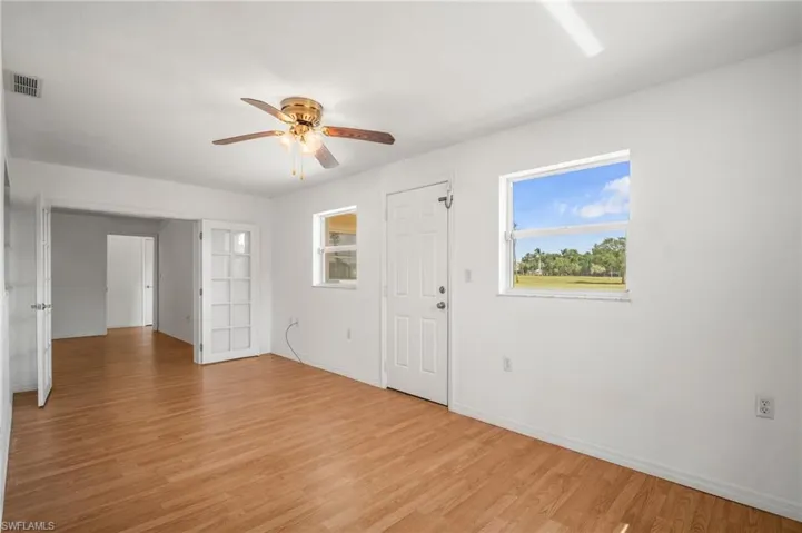 Entrance foyer featuring visible vents, ceiling fan, light wood finished floors, and baseboards