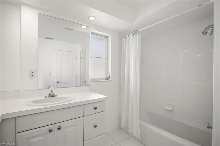 Bathroom featuring recessed lighting, tile patterned flooring, shower / bath combo, and vanity