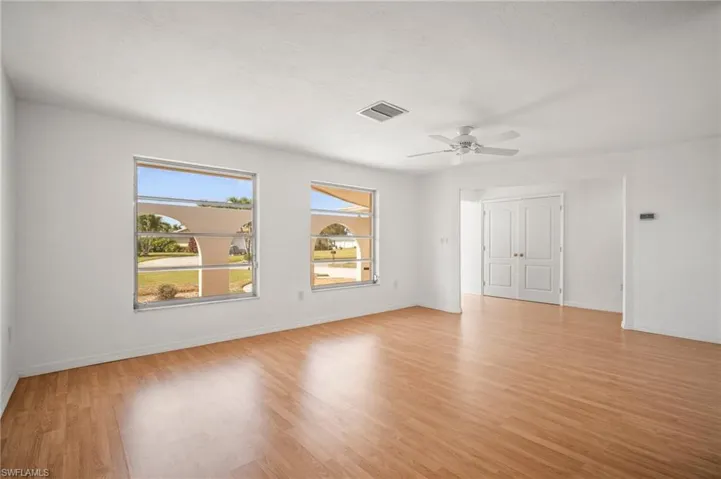 Unfurnished room with baseboards, visible vents, ceiling fan, and light wood finished floors