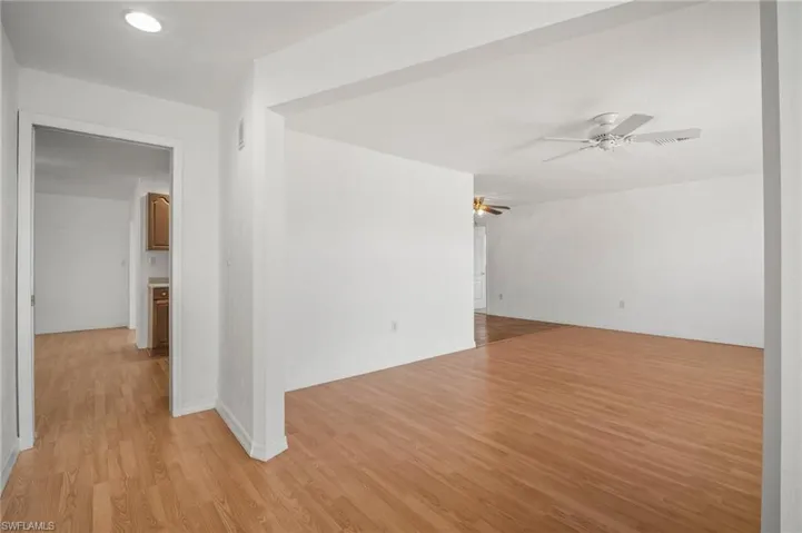 Unfurnished room featuring visible vents, light wood-type flooring, and ceiling fan