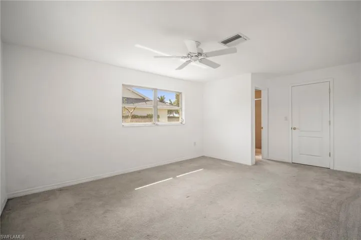 Spare room with visible vents, ceiling fan, carpet flooring, and baseboards