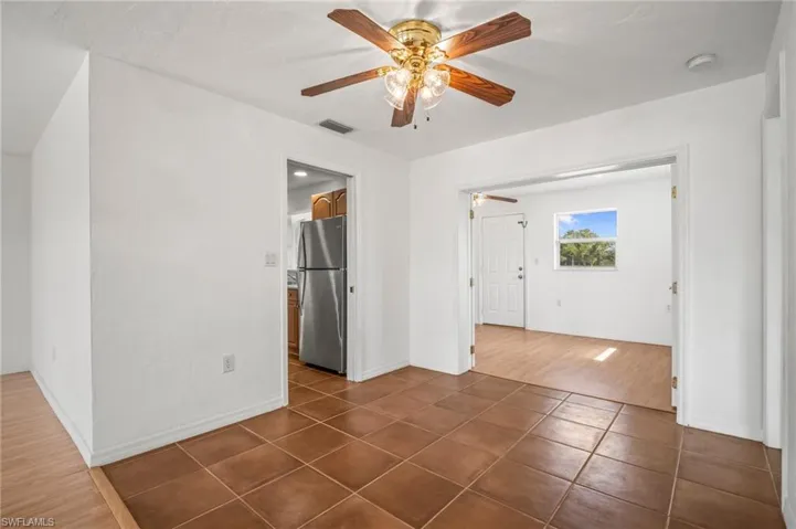 Unfurnished room featuring visible vents, ceiling fan, baseboards, and dark tile patterned flooring