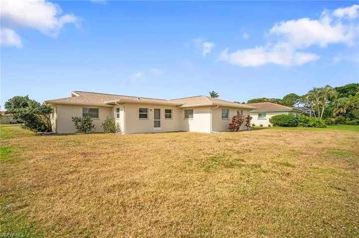 View of front of home featuring stucco siding and a front yard