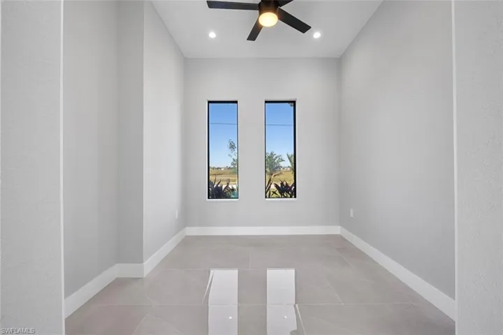 Empty room with a tray ceiling and ceiling fan