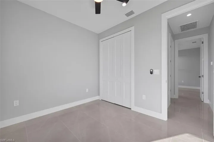 Unfurnished room featuring ceiling fan and light tile patterned flooring