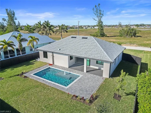 Back of house with a yard, a fenced in pool, and a patio area