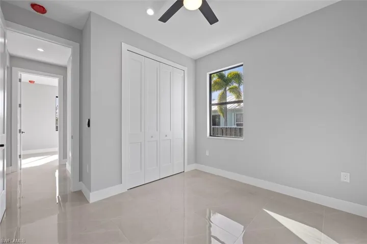 Unfurnished room with ceiling fan, light tile patterned flooring, and a healthy amount of sunlight