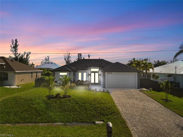 View of front of property with a front lawn and a garage