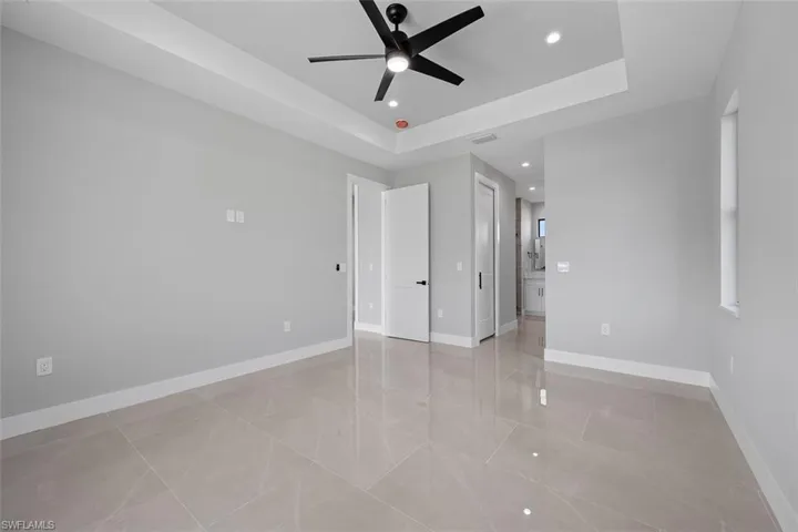 Empty room with a raised ceiling and ceiling fan