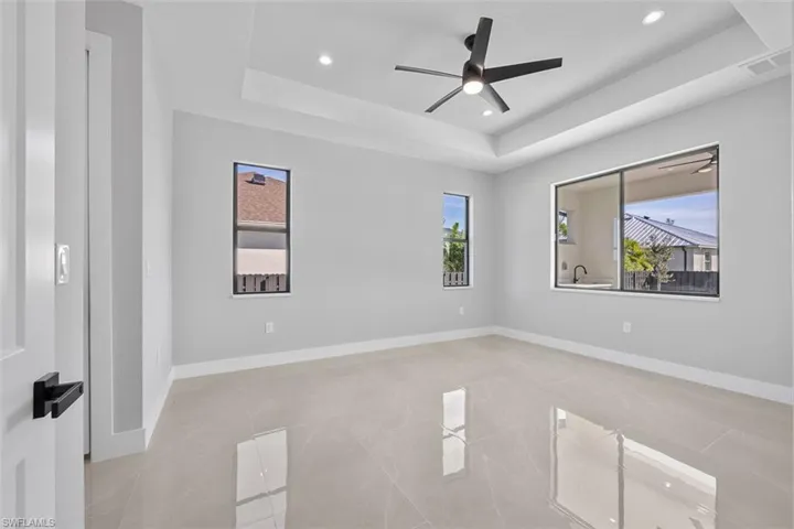 Tiled spare room featuring ceiling fan