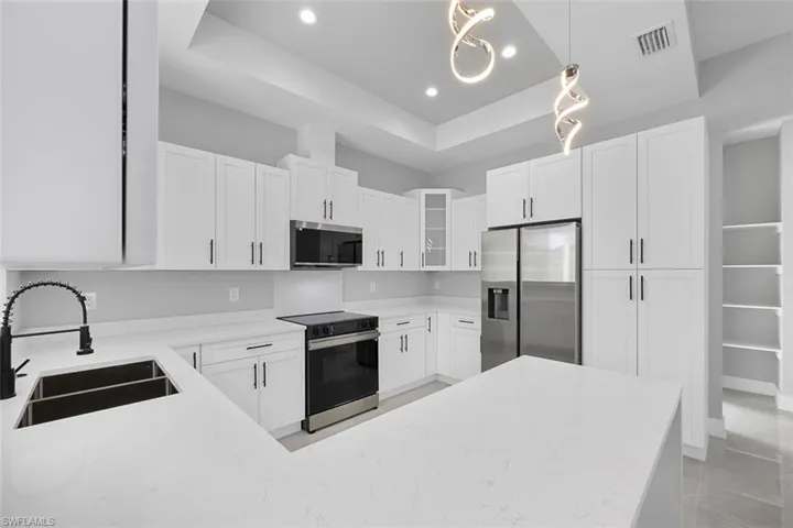 Kitchen featuring white cabinets, stainless steel appliances, and sink