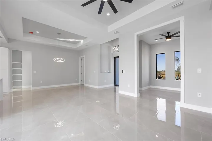 Kitchen featuring a tray ceiling, sink, pendant lighting, and appliances with stainless steel finishes