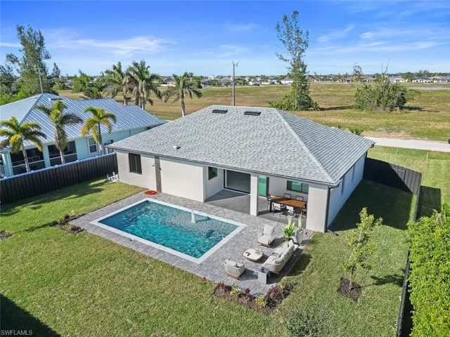 View of pool with pool water feature, ceiling fan, and a patio area