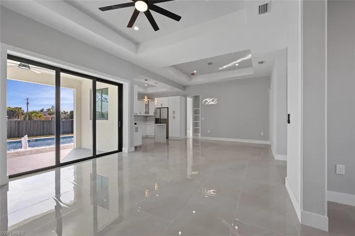 Empty room with ceiling fan and a raised ceiling