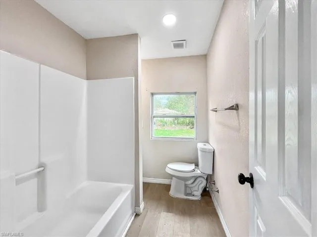 Bathroom with hardwood / wood-style floors and toilet