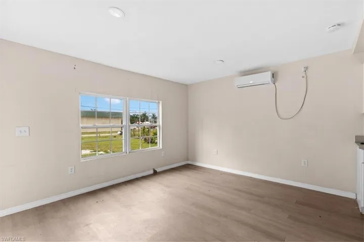Spare room featuring a wall mounted air conditioner and wood-type flooring