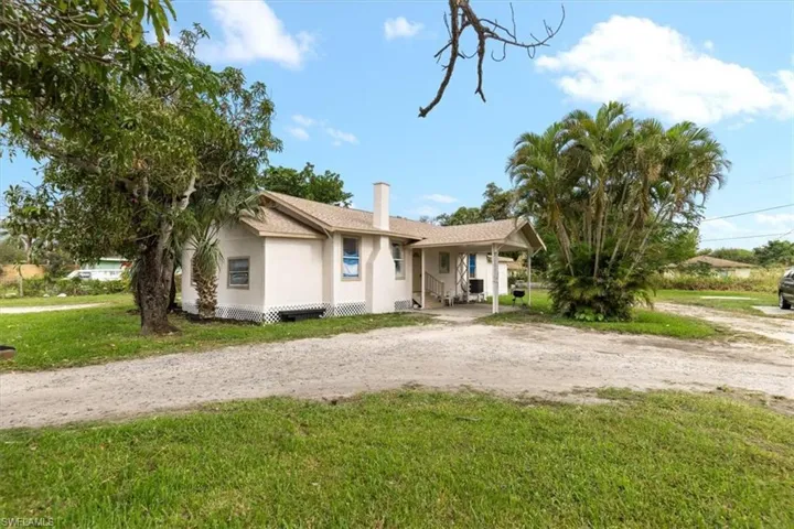 Ranch-style house with a carport and a front yard