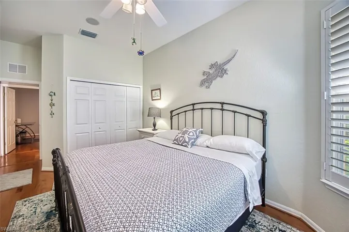 Bedroom featuring ceiling fan, vaulted ceiling, wood-type flooring, and a closet