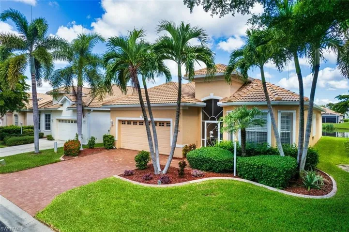 Mediterranean / spanish-style home with a garage and a front lawn