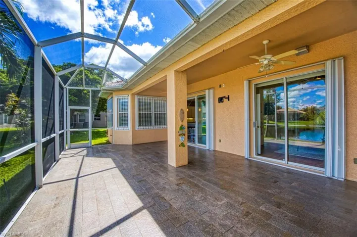 Unfurnished sunroom featuring ceiling fan and a water view