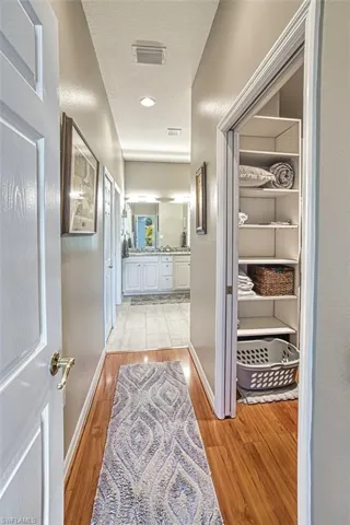 Hallway with a textured ceiling and light hardwood / wood-style flooring
