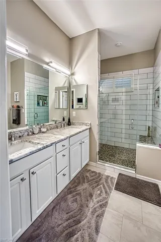 Bathroom featuring tile patterned floors, an enclosed shower, and vanity